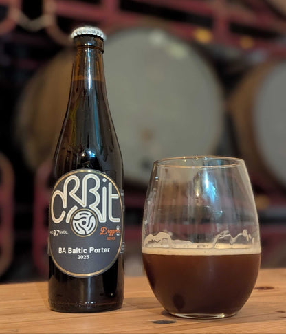 ottle and glass of Orbit BA Baltic Porter beer with barrels in the background